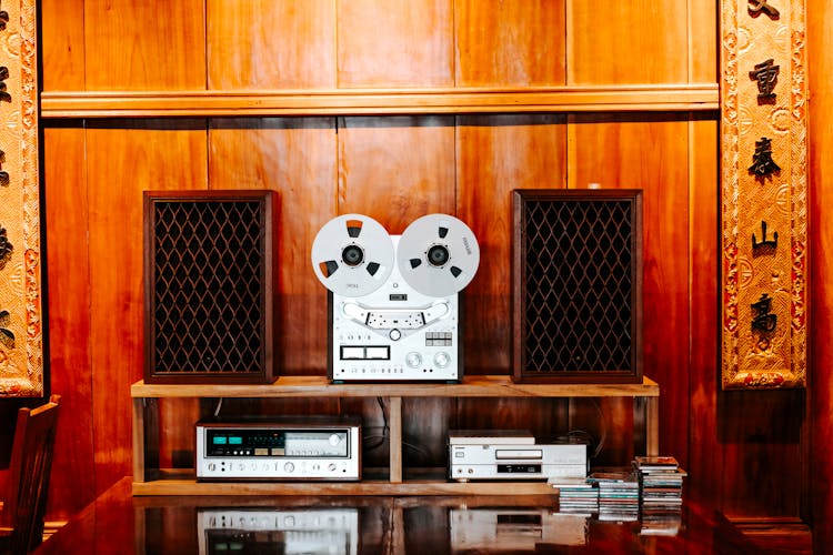 A Film Projector And Dvd Player On A Wooden Shelf