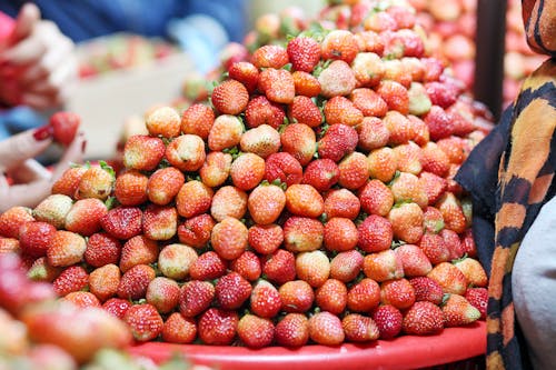 A Stack of Strawberries Displayed on a Red Container