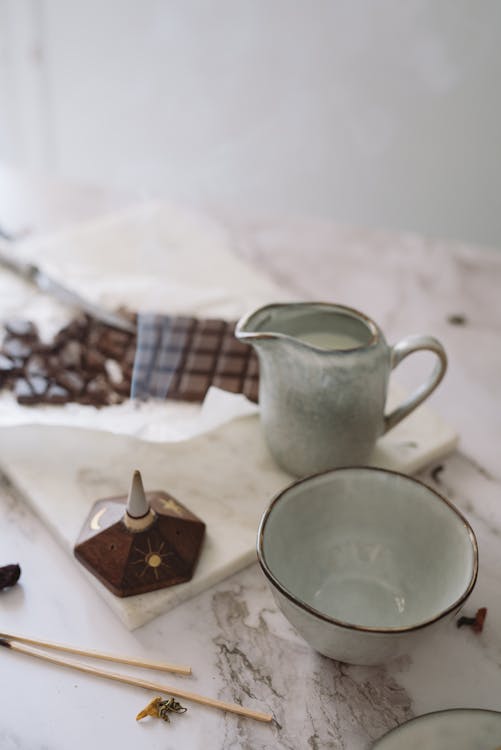 Free A Bowl and Container Near a Bar of Chocolate Stock Photo