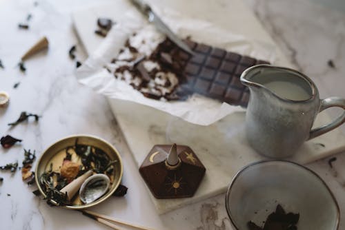 Free Chocolate Bar, Pot with Milk and an Incense Lying on a Table  Stock Photo