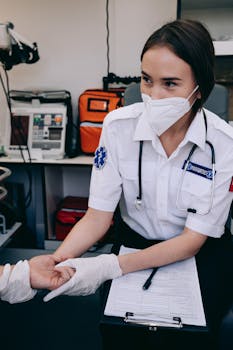 Paramedic using stethoscope while checking pulse of a patient in a clinic setting.