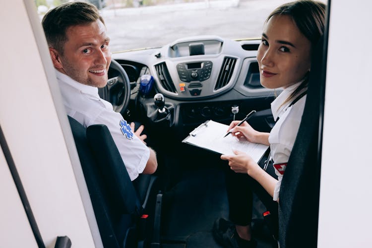 A Man And Woman Sitting Inside The Car