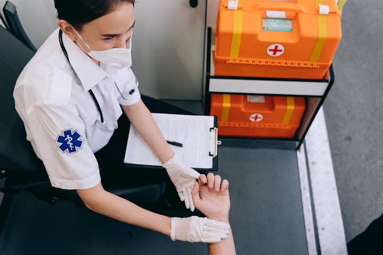 A Paramedic Taking Pulse Of A Patient