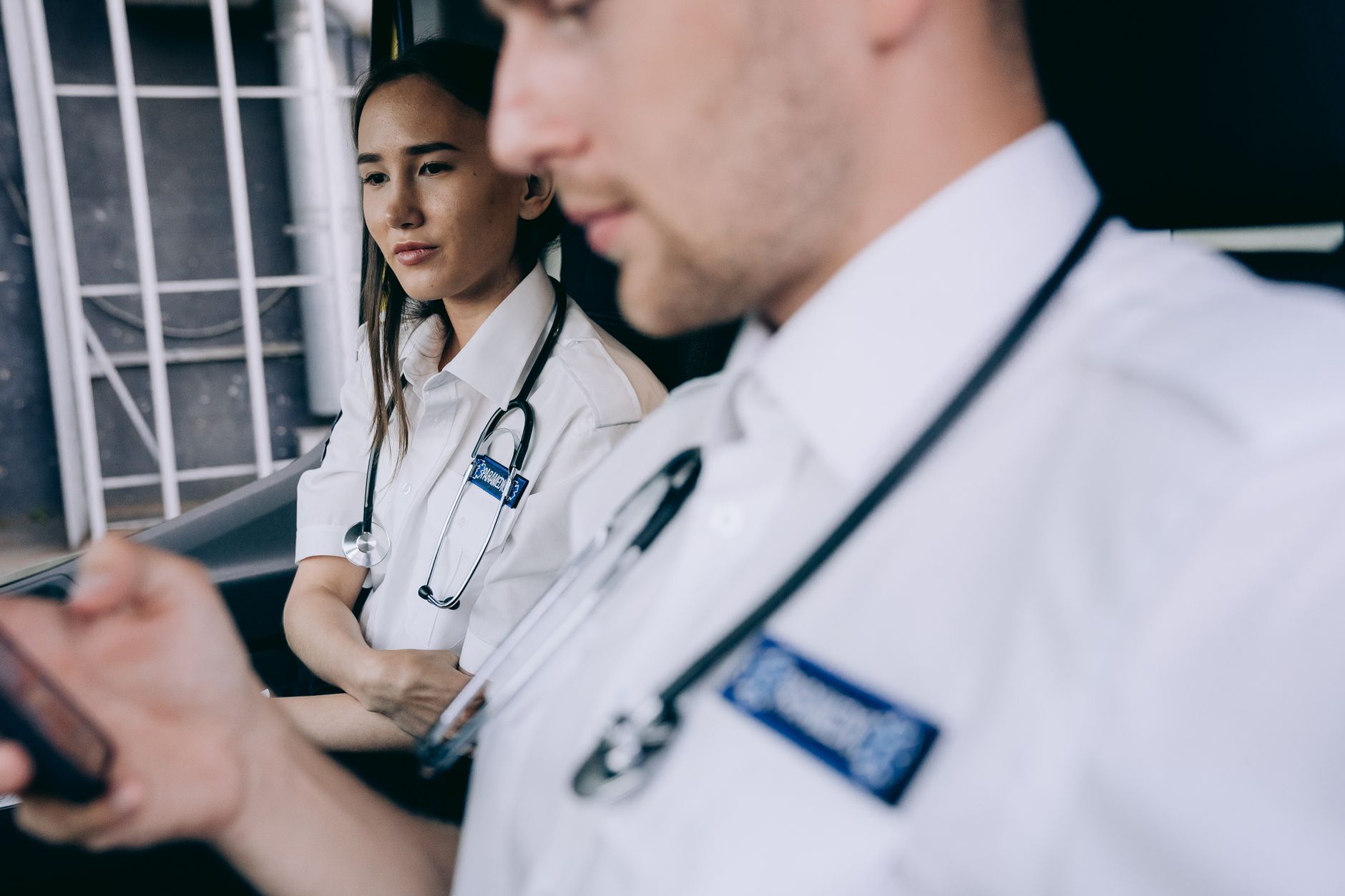Focused emergency medical technicians discussing a case inside an ambulance.