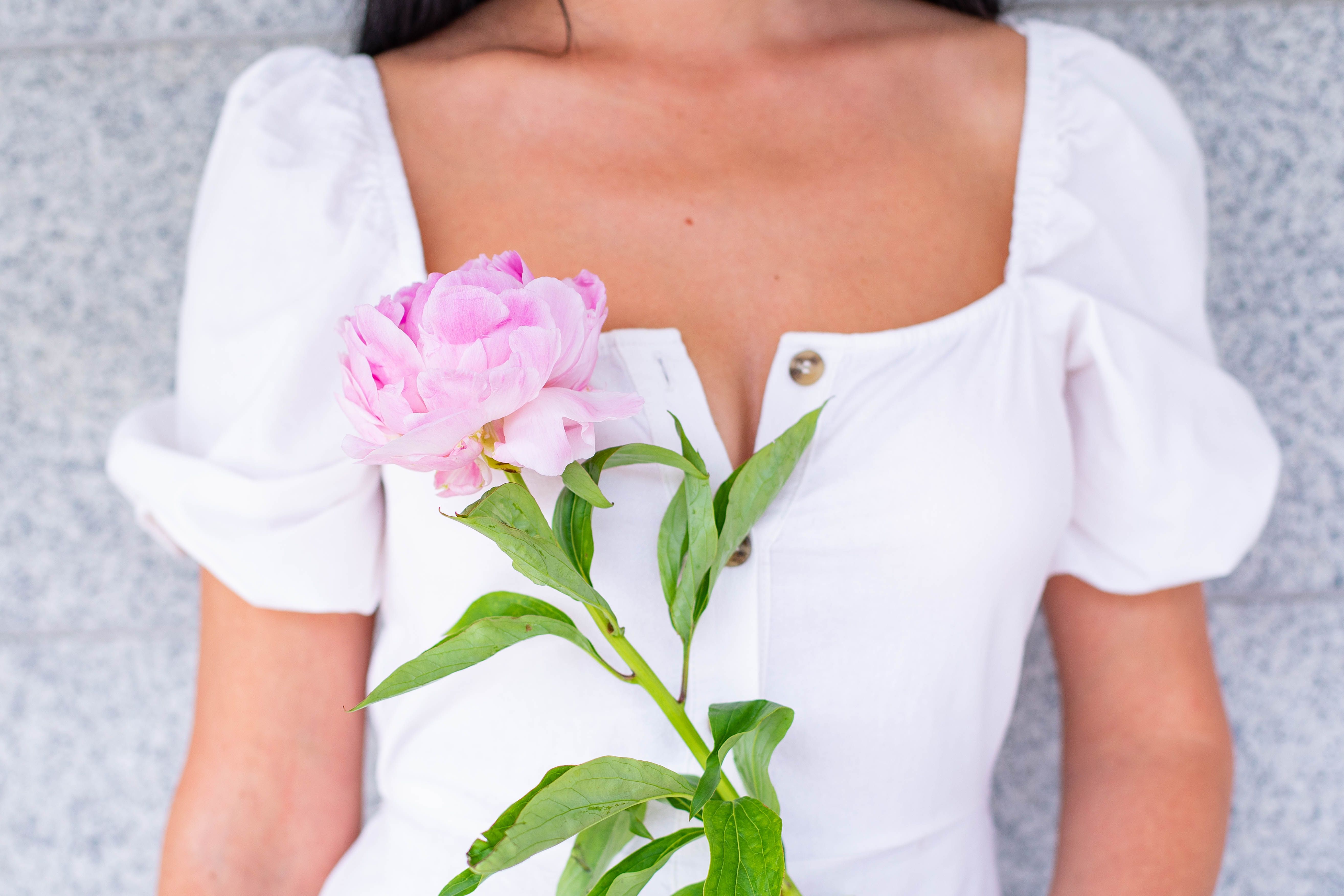 Woman in White Dress Holding a Pink Flowers · Free Stock Photo