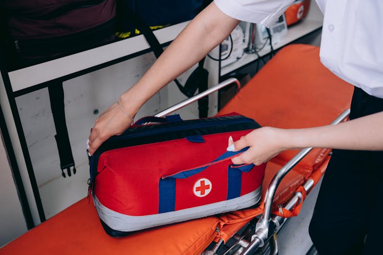 Person Holding Red And Black Bag