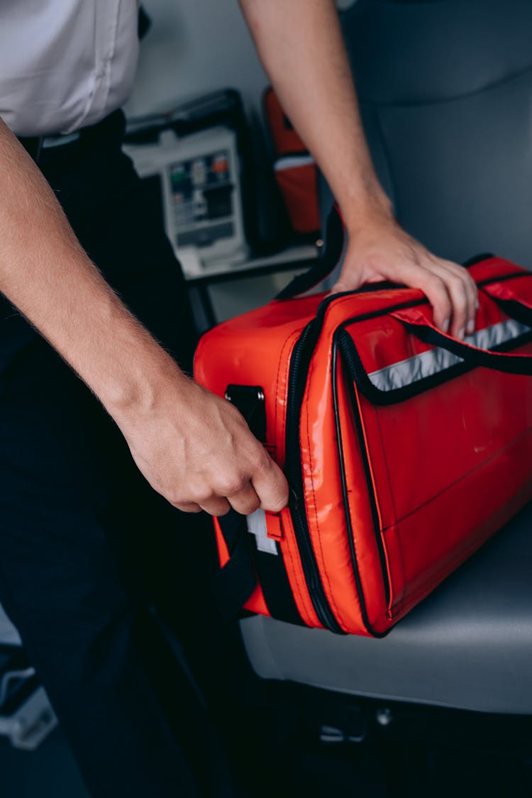 A Paramedic Zipping A Bag