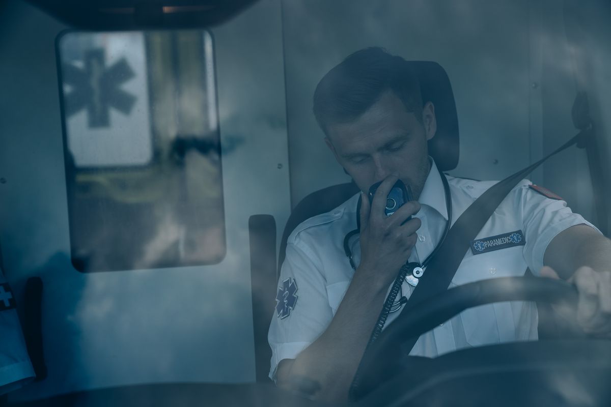Paramédico comunicándose por radio dentro de una ambulancia