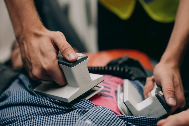 Hands using a defibrillator during CPR training