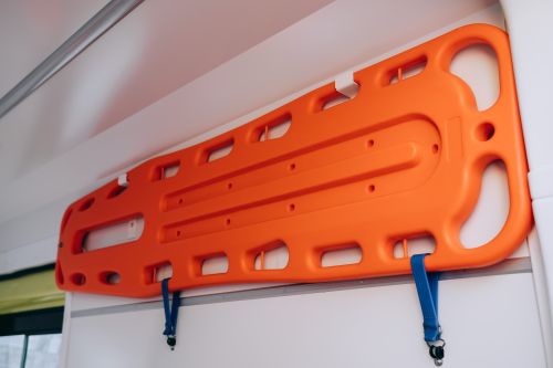 Free Close-up of an orange backboard stretcher mounted in an ambulance, ready for medical emergencies. Stock Photo
