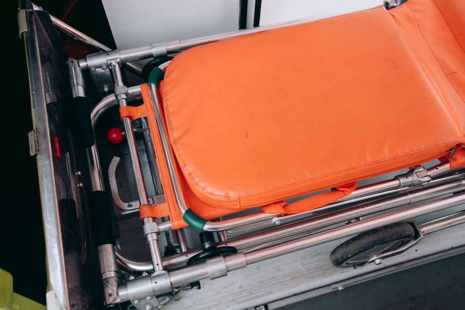 Close-up view of an orange stretcher inside an ambulance, emphasizing medical equipment.