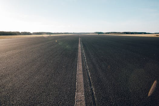 Expansive view of an empty road stretching into the distance under a clear blue sky in Utrecht, Netherlands.