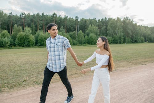 A Couple Walking in the Park Hand in Hand