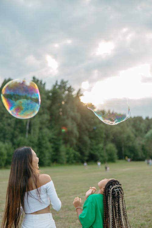 A Person and  a Child Playing with Soap Bubbles