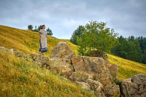 Free A Woman Wearing Dress while Standing on Rock Formation Stock Photo
