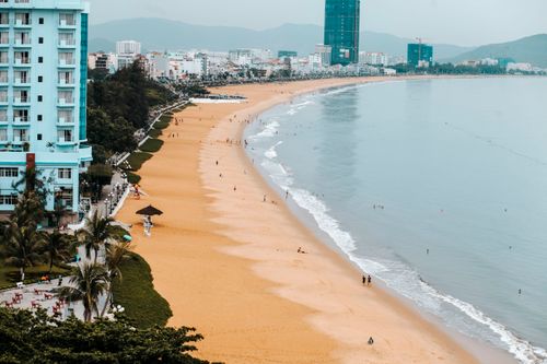 Free Aerial view of a sandy beach alongside a bustling cityscape, perfect for relaxation and leisure. Stock Photo