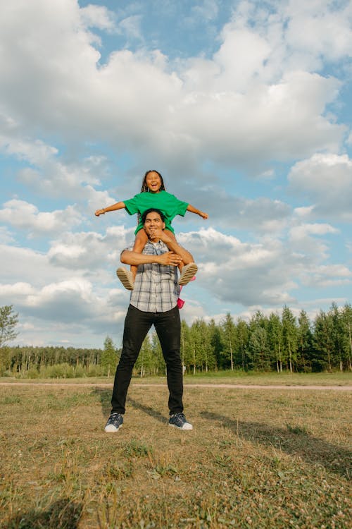 Free A Man Carrying a Girl on His Shoulders Stock Photo