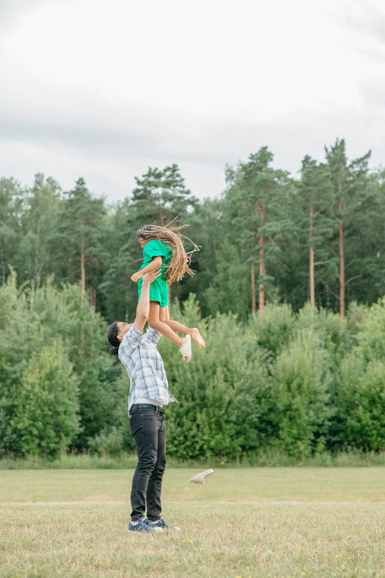 Man Lifting A Girl At The Park