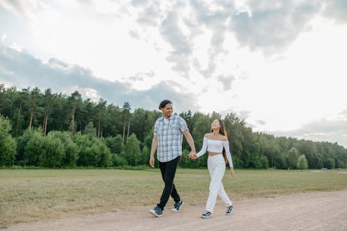 Free A Couple Walking on a Dirt Path While Holding Hands Stock Photo