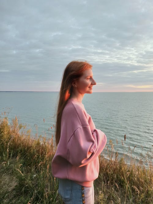 Free Woman Wearing Pink Sweater Looking at the Sea Stock Photo