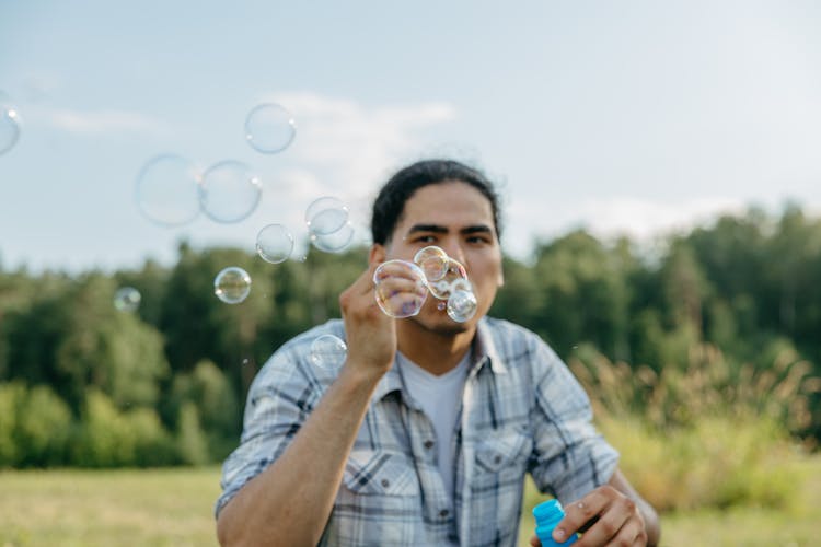 A Man Blowing A Soap Bubbles