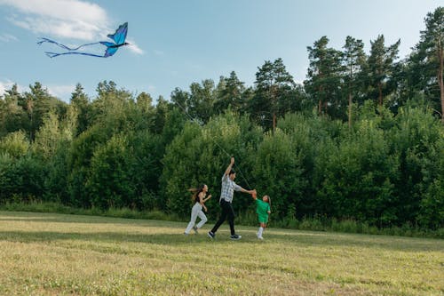 Photo of a Family Playing with a Kite Together