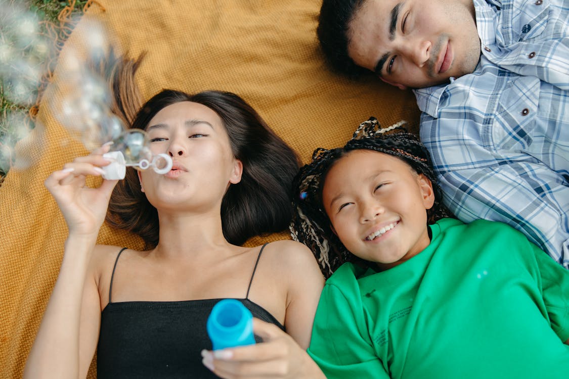Free A Woman Blowing Bubbles while Lying Down Stock Photo