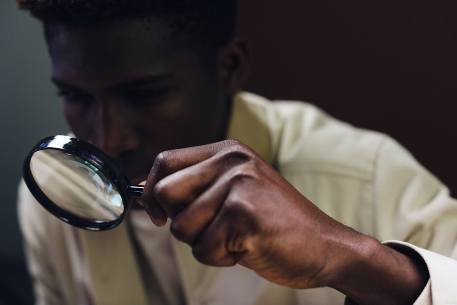 black man looking through magnifying glass