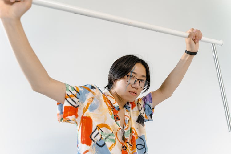 A Man In Colorful Shirt Holding On The White Grab Bar