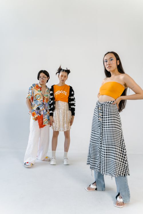 Free Three young adults in trendy outfits posing confidently in a bright studio. Stock Photo