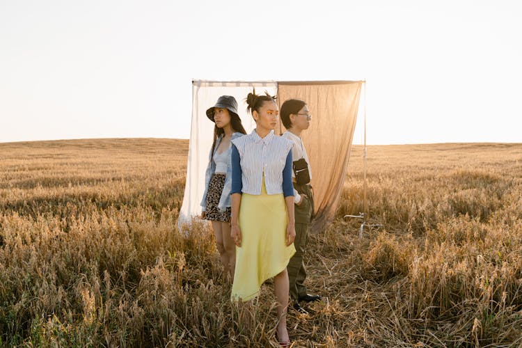 Women Standing On Brown Grass Field