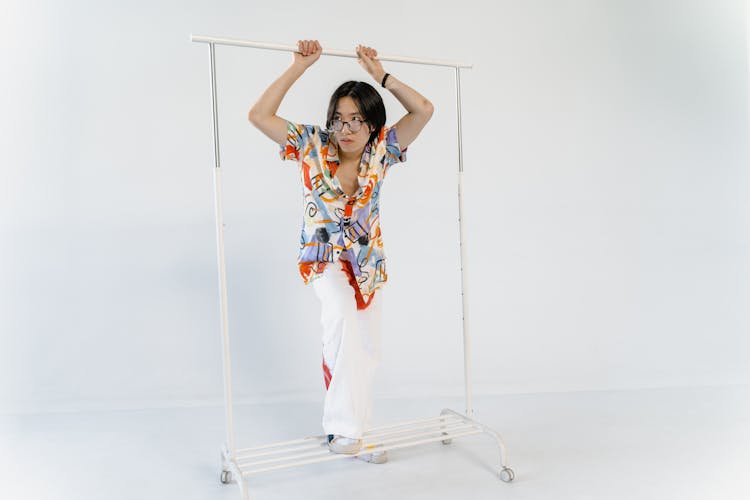 A Stylish Boy Holding A Clothes Rack