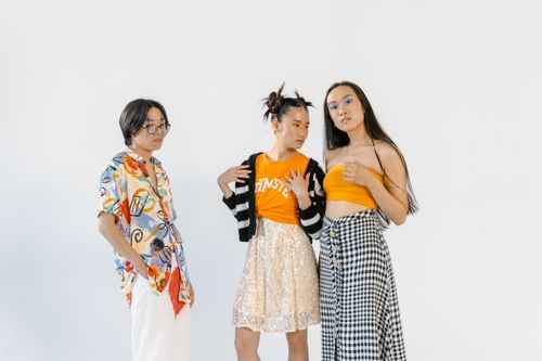 Free Three stylish teenagers posing together in colorful, trendy attire against a white background. Stock Photo