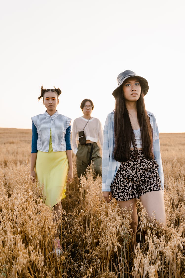 Photograph Of Fashionable Girls And A Boy In A Grass Field