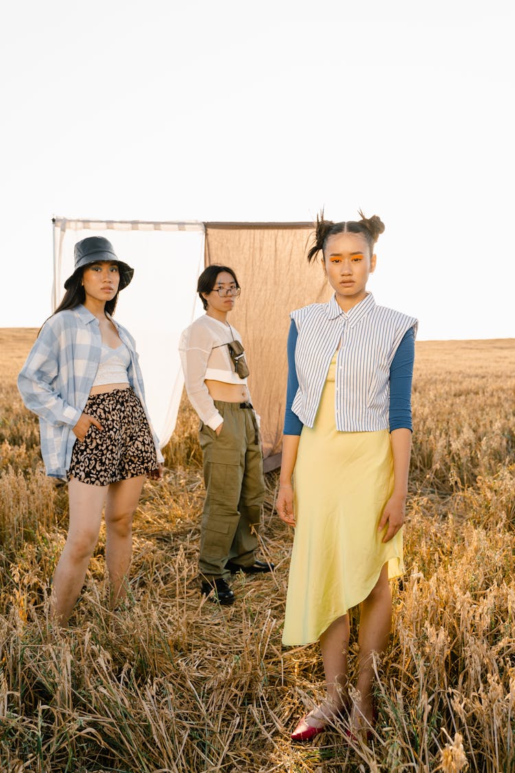 Photo Of Girls And A Boy Posing In A Grass Field