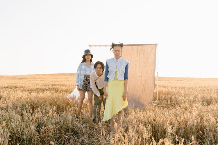 Photo Of Fashionable Girls And A Boy Posing On The Grass