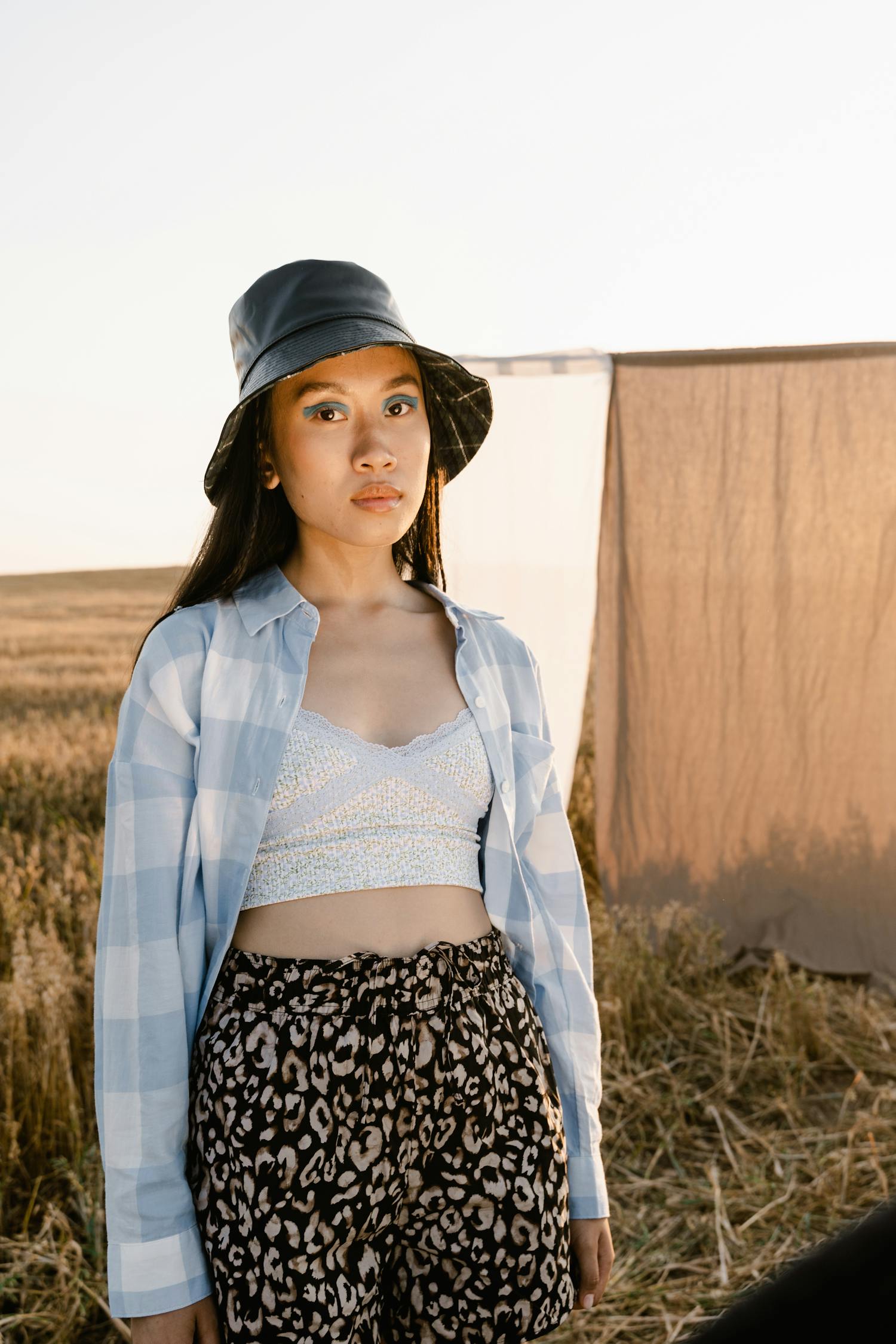 A Girl Posing while Wearing a Bucket Hat on the Field