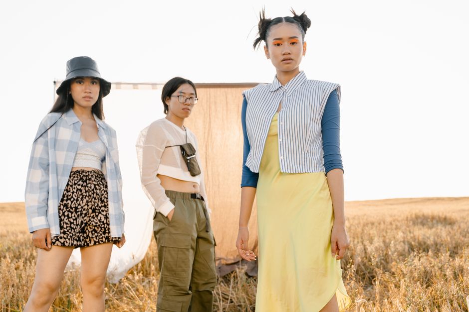 A group of stylish Asian teenagers posing in a sunlit field, showcasing modern fashion trends.