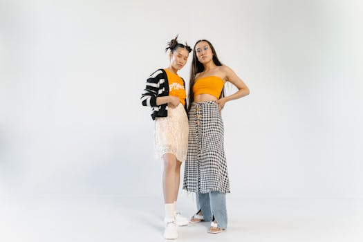Studio fashion portrait featuring two stylish women in vibrant outfits with a clean background.