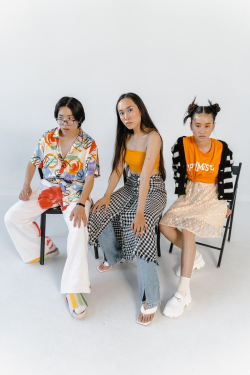 Free Fashionable young adults in stylish attire seated in a modern studio setting. Stock Photo