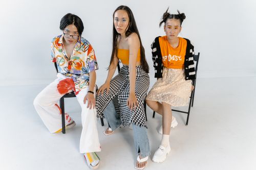 Free Three young models posing in vibrant urban fashion for a studio photoshoot. Stock Photo