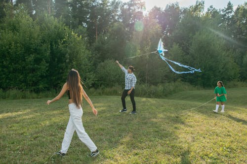 Man Flying a Kite with his Children