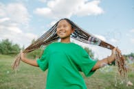 Shallow Focus of a Girl in Green Shirt Holding Her Braided Hair