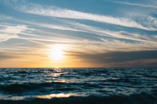 Free Captivating ocean sunset showcasing a vivid sky and gentle waves, perfect for tranquil scenes. Stock Photo