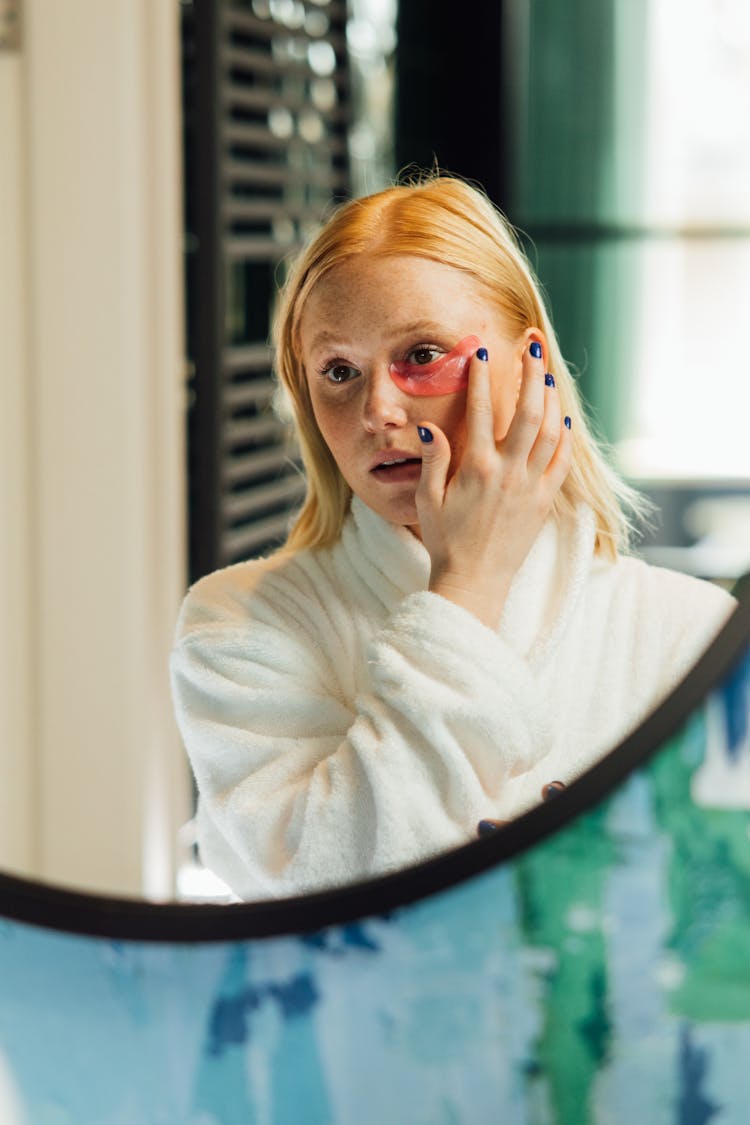 A Woman Applying An Eye Mask