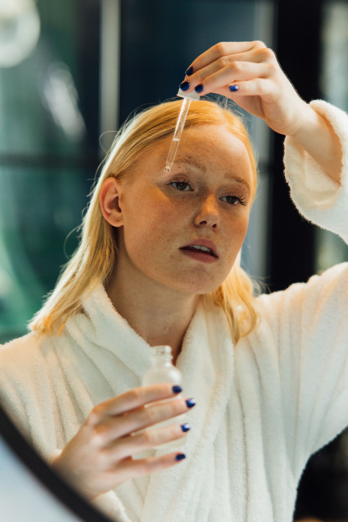 Woman applying a gentle beginner retinol product as part of a self-care routine