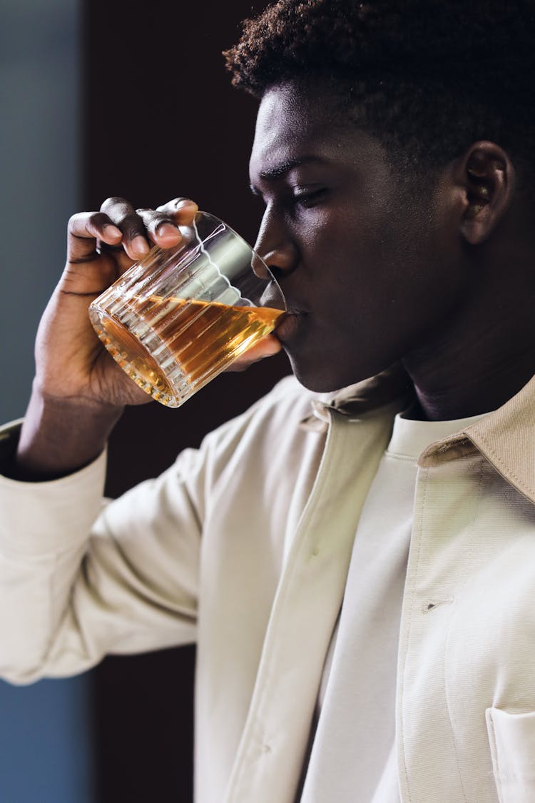 Close-Up Shot Of A Man Drinking A Glass Of Liquor