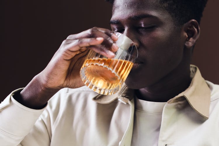 Close-Up Shot Of A Man Drinking A Glass Of Liquor