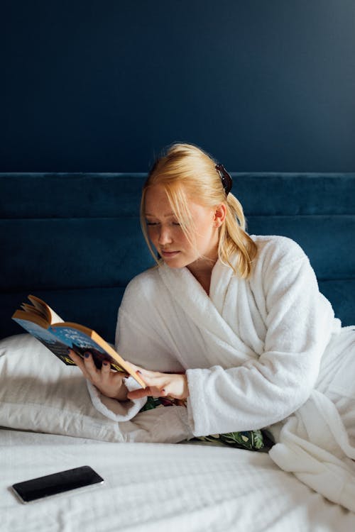 Free Woman in White Robe Reading a Book Stock Photo