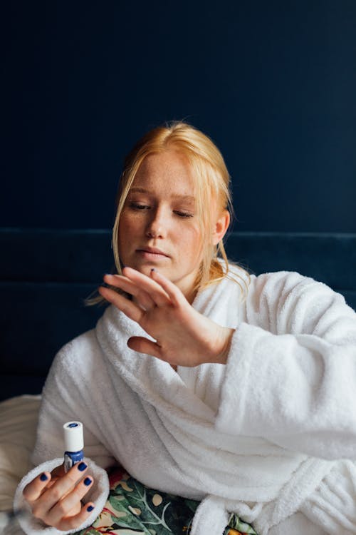 Free Woman in White Bathrobe Looking on Her Manicured Nails Stock Photo